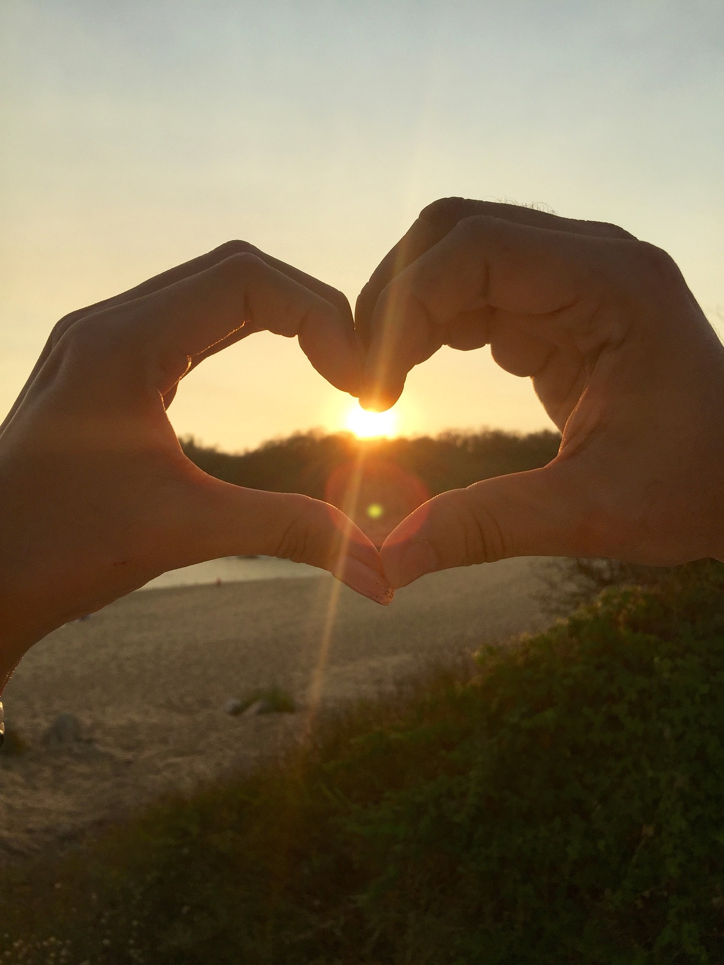 a hands making a heart shape with the sun behind them, pschychoterapia dla par